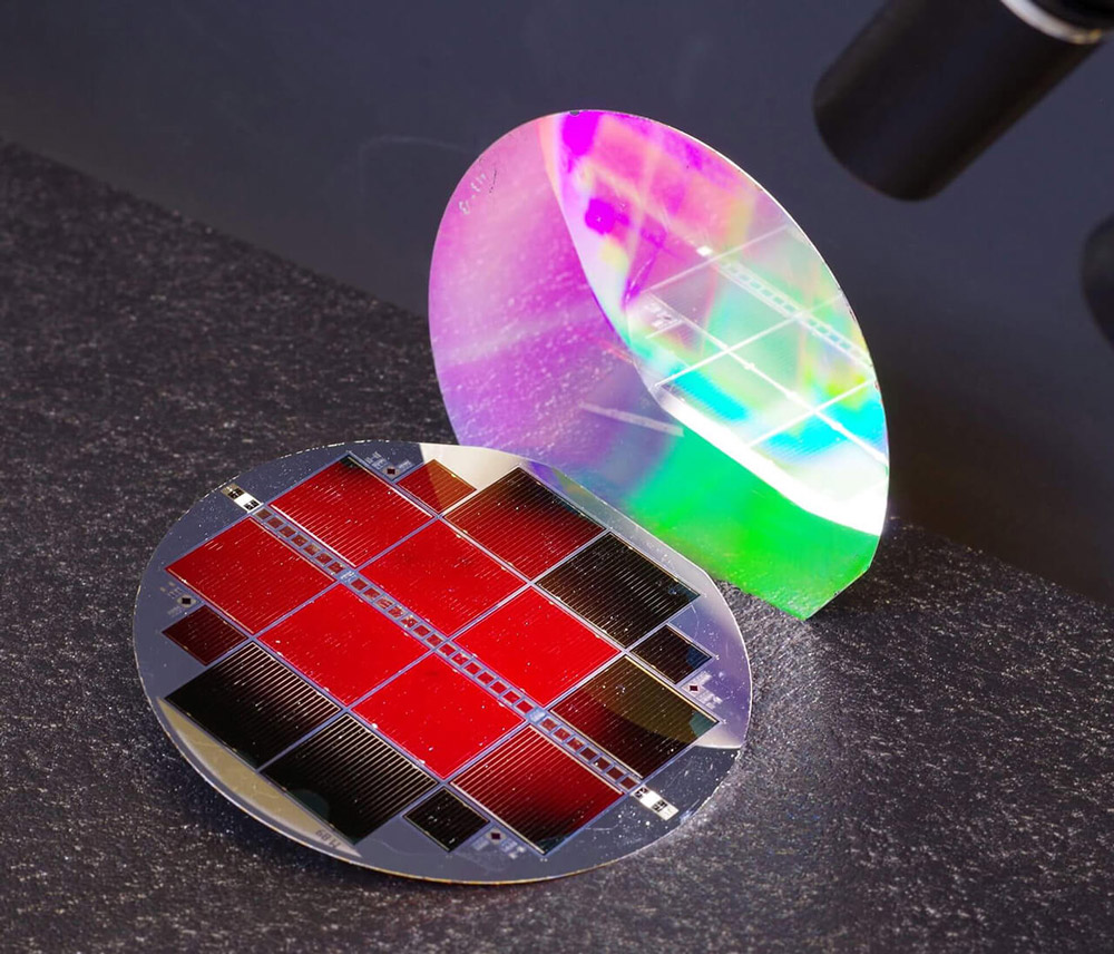 The new 35.9%-efficient III-V//Si tandem solar cell. The top subcell glows red, which is a sign of outstanding material quality. The nanostructured back side of the cell shimmers in rainbow colors. 