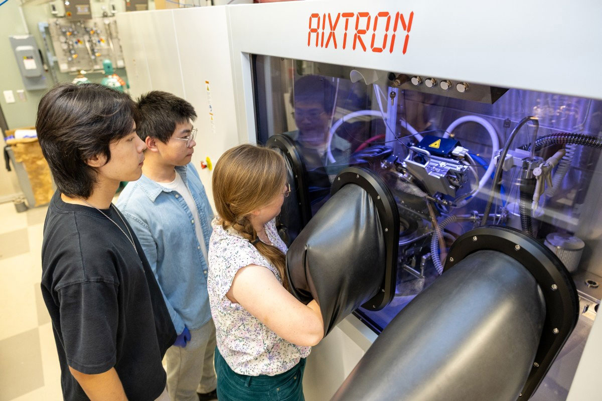 From left: doctoral students Wenyuan Yan and Yuxuan Deng observe as postdoctoral researcher Isabel Streicher operates a new MOCVD system. Photo courtesy of Charissa King-O'Brien. 